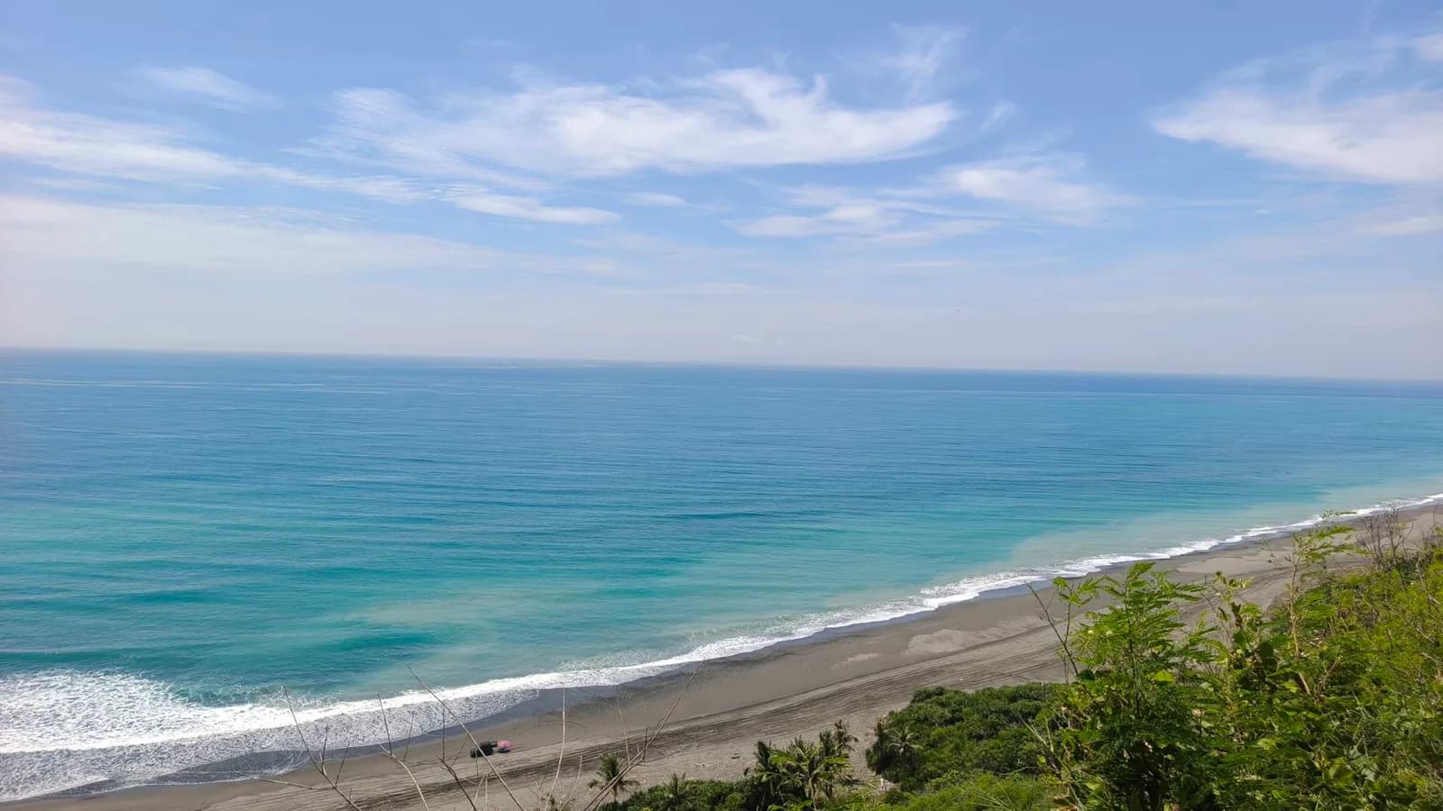 灰色長沙灘拉成一條線，海水由淺綠轉深（實景・五星台東旅遊自攝）