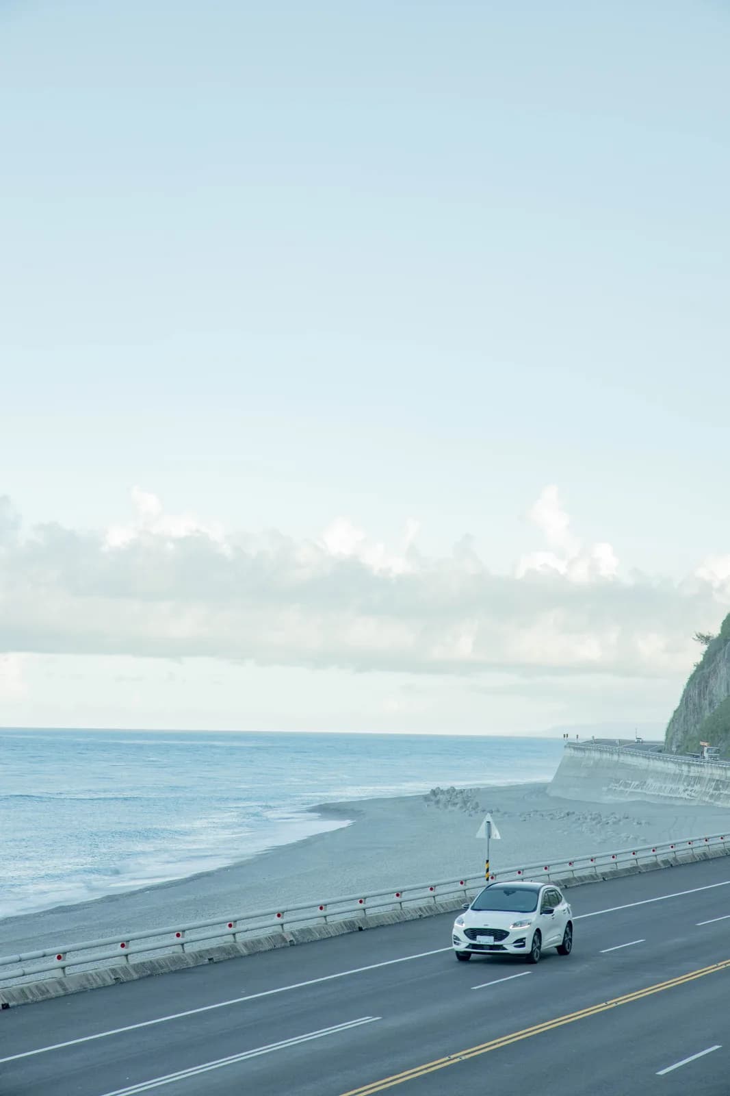 一台白色汽車走在起著海霧的公路上(實景・Pexels 授權)