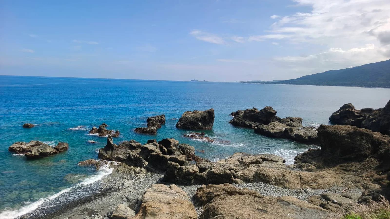 礁岩往海灣延伸,岸邊是卵石灘(實景・五星台東旅遊自攝)